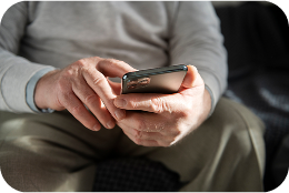 Manos de una persona mayor manejando un móvil