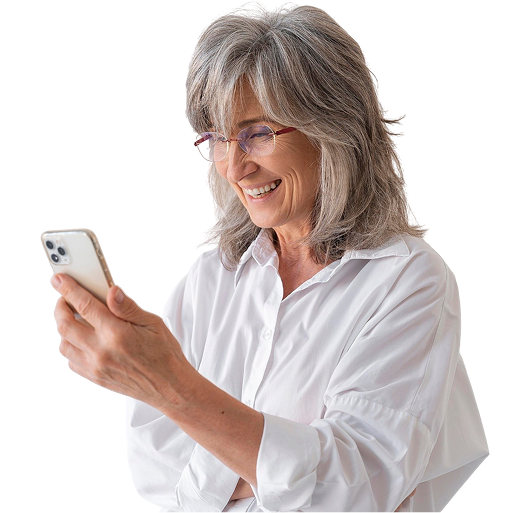 Mujer con gafas y pelo canoso, con una camisa blanca mirando su móvil sonriendo